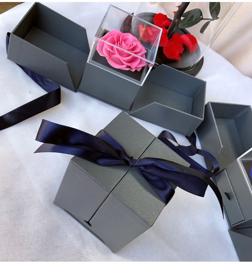 Acrylic rose drawer gift boxes arranged on table with ribbon, minimalist proposal gift setup